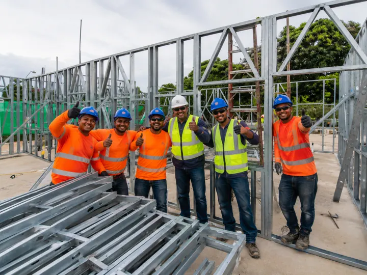 Cuadrilla de montaje con estructura de Steel Framing al fondo